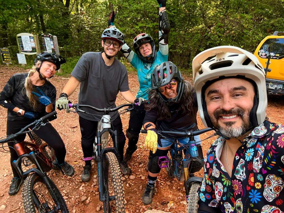 Five riders smiling for a trailhead selfie before a guided Bentonville ride