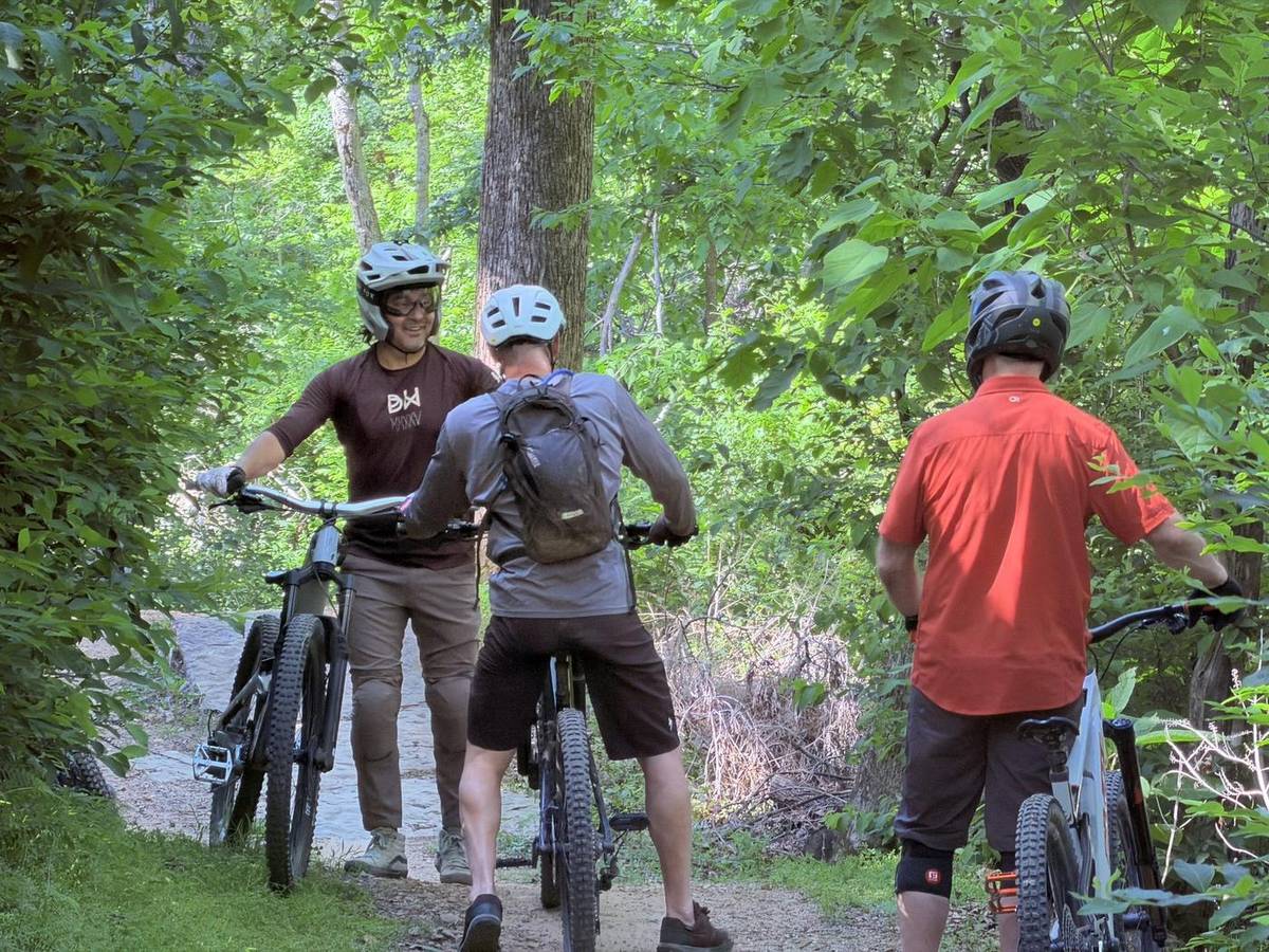 Guided riders pausing for a trail chat on Bentonville singletrack